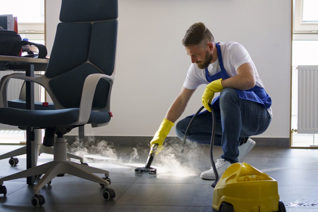 professional cleaning service person using steam cleaner office